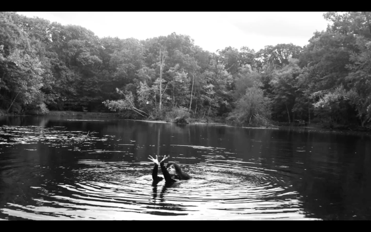 Nicole Antebi posing for a photo in a lake, black and white.